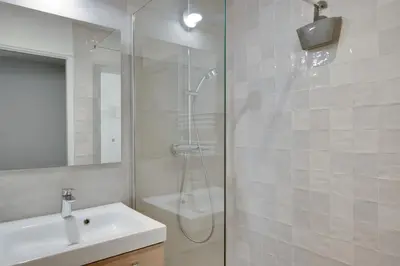 a bathroom with a shower and a sink and a mirror at Gold Apartment in Cannes