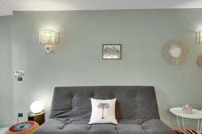 a gray couch with a palm tree pillow on it at Gold Apartment in Cannes