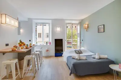 a room with two beds and a kitchen and a table at Gold Apartment in Cannes