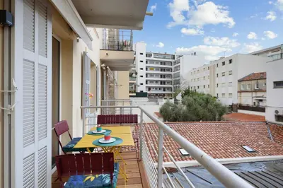 a balcony with a table and chairs on a building at Gold Apartment in Cannes