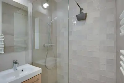 a white bathroom with a shower and a sink at Gold Apartment in Cannes