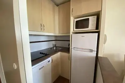 a small kitchen with a refrigerator and a microwave at C021 Lumineux appartement avec Terrasse et Piscine in Cannes