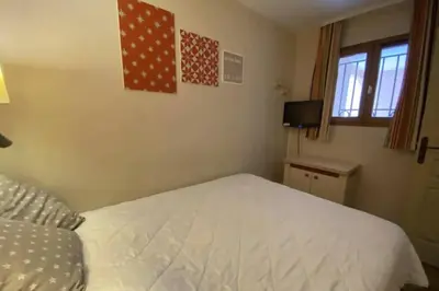 a bedroom with a white bed and a television at C021 Lumineux appartement avec Terrasse et Piscine in Cannes