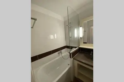 a bathroom with a tub and a sink and a mirror at C021 Lumineux appartement avec Terrasse et Piscine in Cannes