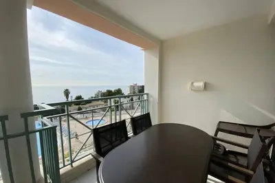 a dining room with a table and a view of the ocean at C021 Lumineux appartement avec Terrasse et Piscine in Cannes