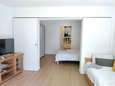 a living room with two beds and a television at Idéal pied à terre proche Cannes & Sophia, parking in Mougins