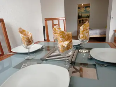 a table with two wine glasses and plates on it at Idéal pied à terre proche Cannes & Sophia, parking in Mougins