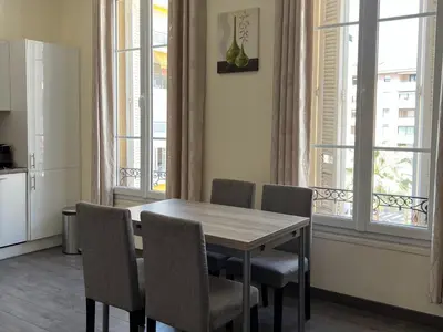 a table and chairs in a kitchen with windows at Cannes Centre, 3 Chambres, Plage et La Croisette à 50m in Cannes