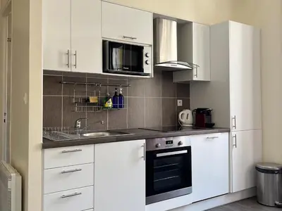 a kitchen with white cabinets and a microwave at Cannes Centre, 3 Chambres, Plage et La Croisette à 50m in Cannes