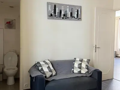 a living room with a blue couch and a toilet at Cannes Centre, 3 Chambres, Plage et La Croisette à 50m in Cannes