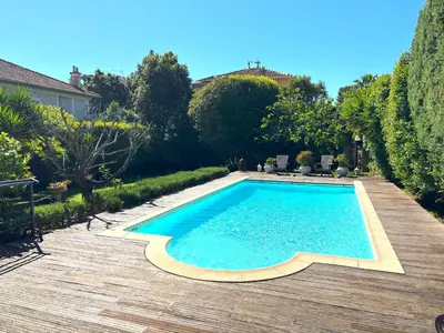 a swimming pool in a yard with a wooden deck at Cannes Charming Villa Private Pool near beaches new award 10 out of 10 in Le Cannet