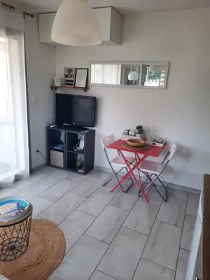 a living room with a red table and a television at Studio Croix des Gardes Palais Plages in Cannes