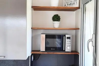 a microwave sitting on a shelf in a kitchen at Studio Croix des Gardes Palais Plages in Cannes