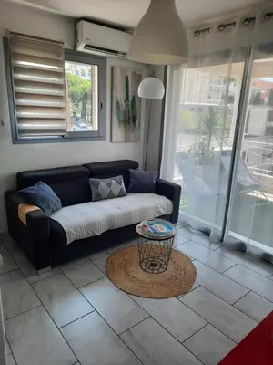 a living room with a couch and a table at Studio Croix des Gardes Palais Plages in Cannes
