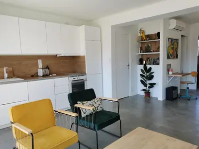 a kitchen with white cabinets and two chairs and a table at Sunset Loft in Cannes