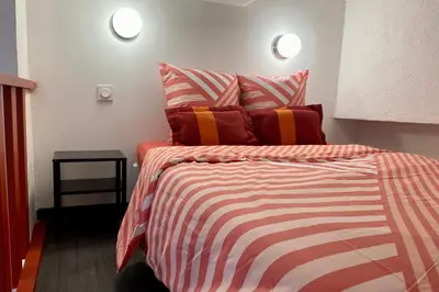a bedroom with a bed with striped sheets and pillows at Red Calmette in Cannes