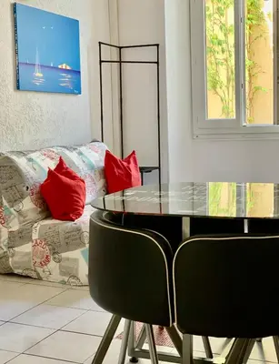 a dining room with a glass table and a couch at Red Calmette in Cannes