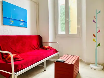 a red couch in a room with a window at Red Calmette in Cannes