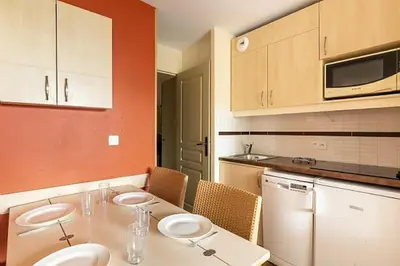 a kitchen with a table with three plates on it at Résidence Cannes Villa Francia - maeva Home - Appartement 2 Pièces 4 Personnes - Confort MAE-4184 in Cannes
