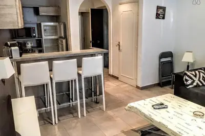 a living room with a bar with white stools at C038-Elegant apt a few steps from beaches - Le Suquet in Cannes