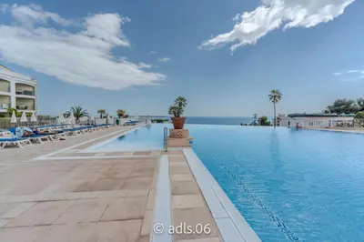 a swimming pool at a resort with palm trees at Un Studio de Charme Vue Mer & Piscine d'Exception in Cannes