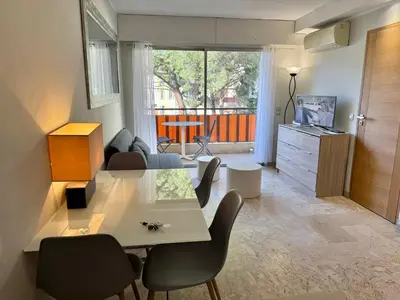 a living room with a table and chairs and a television at Apartment 2 pièces Cannes Centre in Cannes