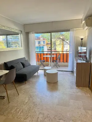 a living room with a couch and a large window at Apartment 2 pièces Cannes Centre in Cannes