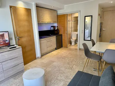 a living room with a table and a kitchen at Apartment 2 pièces Cannes Centre in Cannes