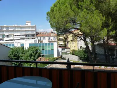 a person walking on a balcony with a tree at Apartment 2 pièces Cannes Centre in Cannes