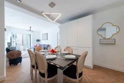a dining room and living room with a table and chairs at 3-Br apartment in the Golden Square in Cannes