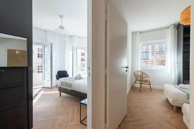 a bedroom with a bed and a room with a bed and a couch at 3-Br apartment in the Golden Square in Cannes