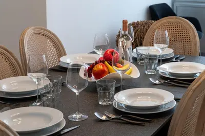 a table with plates and glasses and a bowl of fruit at 3-Br apartment in the Golden Square in Cannes