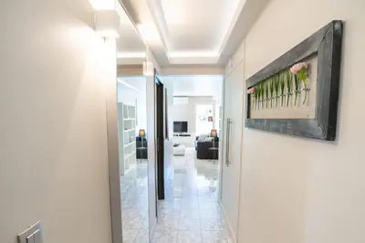 a hallway leading to a living room with a painting on the wall at 2-Bedroom Apartment Pointe Croisette Peaceful Walk to the Beach in Cannes