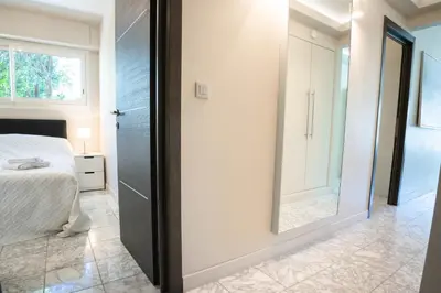 a bedroom with a mirror next to a bed at 2-Bedroom Apartment Pointe Croisette Peaceful Walk to the Beach in Cannes