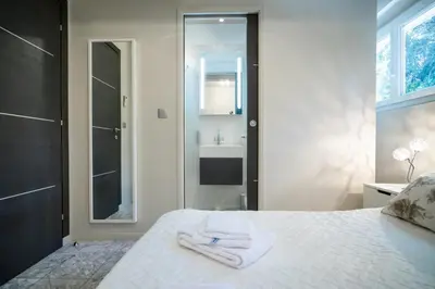 a bathroom with a bed with a sink and a mirror at 2-Bedroom Apartment Pointe Croisette Peaceful Walk to the Beach in Cannes