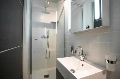 a white bathroom with a sink and a shower at 2-Bedroom Apartment Pointe Croisette Peaceful Walk to the Beach in Cannes