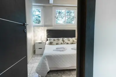 a bedroom with a bed and two windows at 2-Bedroom Apartment Pointe Croisette Peaceful Walk to the Beach in Cannes