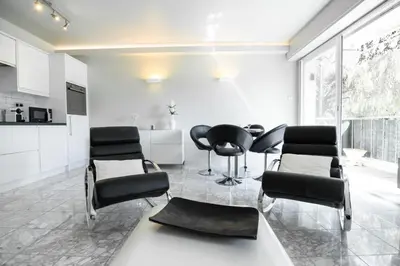 a living room with black chairs and a table at 2-Bedroom Apartment Pointe Croisette Peaceful Walk to the Beach in Cannes