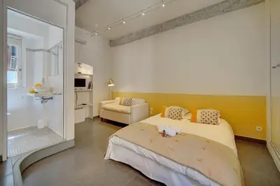 a bedroom with a bed and a chair in it at Joli Studio VIEUX PORT-BAS SUQUET A0B065 in Cannes