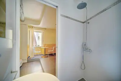 a bathroom with a shower and a room with a table at Joli Studio VIEUX PORT-BAS SUQUET A0B065 in Cannes