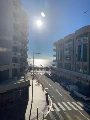 a city street with buildings and the ocean in the background at Somptueux logement,Cannes Croisette,4 Étoiles**** in Cannes