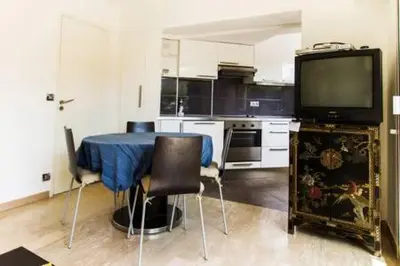 a kitchen with a table and a tv in it at NICE FLAT WITH GARDENS Limites cannes juste 10 MNS CROISETT in Le Cannet