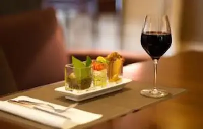 a glass of wine and a plate of food on a table at NICE FLAT WITH GARDENS Limites cannes juste 10 MNS CROISETT in Le Cannet
