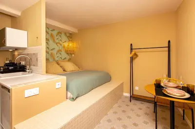 a bedroom with a bed and a sink and a table at Le Saint Victor Coeur de Cannes in Cannes