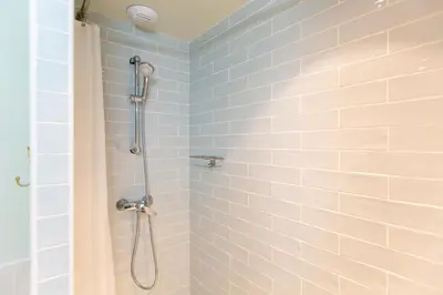 a bathroom with a shower with blue tiles at Le Saint Victor Coeur de Cannes in Cannes