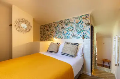 a bedroom with a bed with a yellow bedspread at Le Saint Victor Coeur de Cannes in Cannes