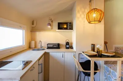 a small kitchen with a sink and a table at Le Saint Victor Coeur de Cannes in Cannes