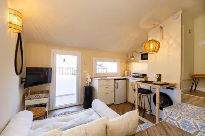 a living room with a white couch and a kitchen at Le Saint Victor Coeur de Cannes in Cannes