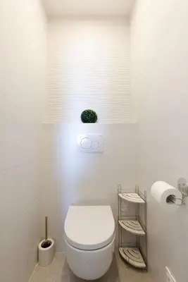a white bathroom with a toilet and a window at Fettolina in Cannes