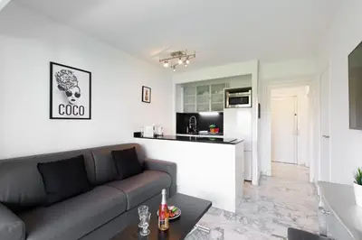 a living room with a couch and a kitchen at Phoenix YourHostHelper in Cannes